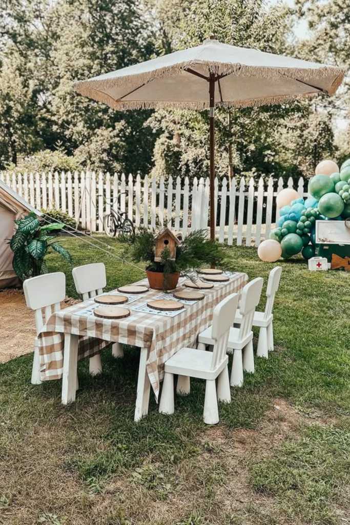 Outdoor kids birthday dining table under a large umbrella