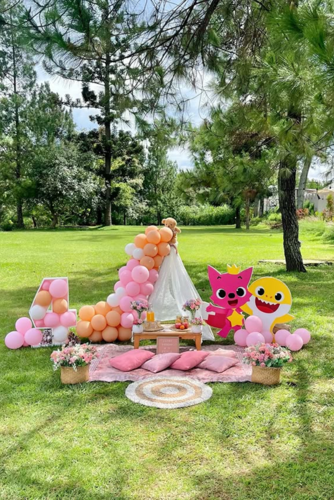 Outdoor birthday picnic blanket with balloons and character decorations