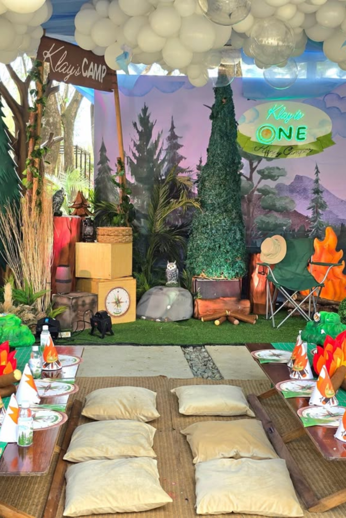 Camping themed outdoor birthday area with forest decorations