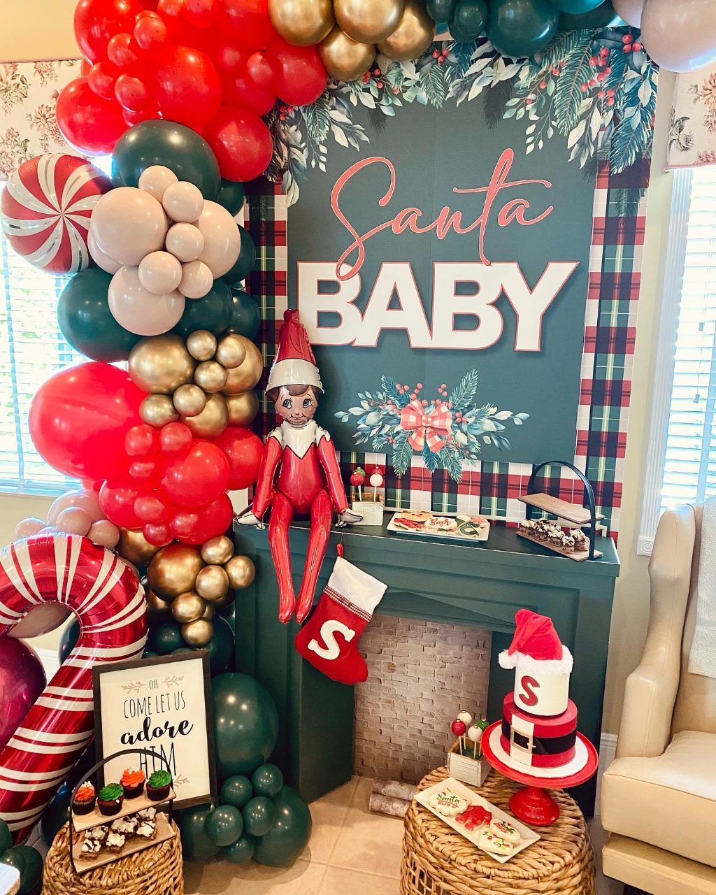 Santa Baby fireplace corner with an elf, stocking, holiday cookies, cake, and candy cane balloons