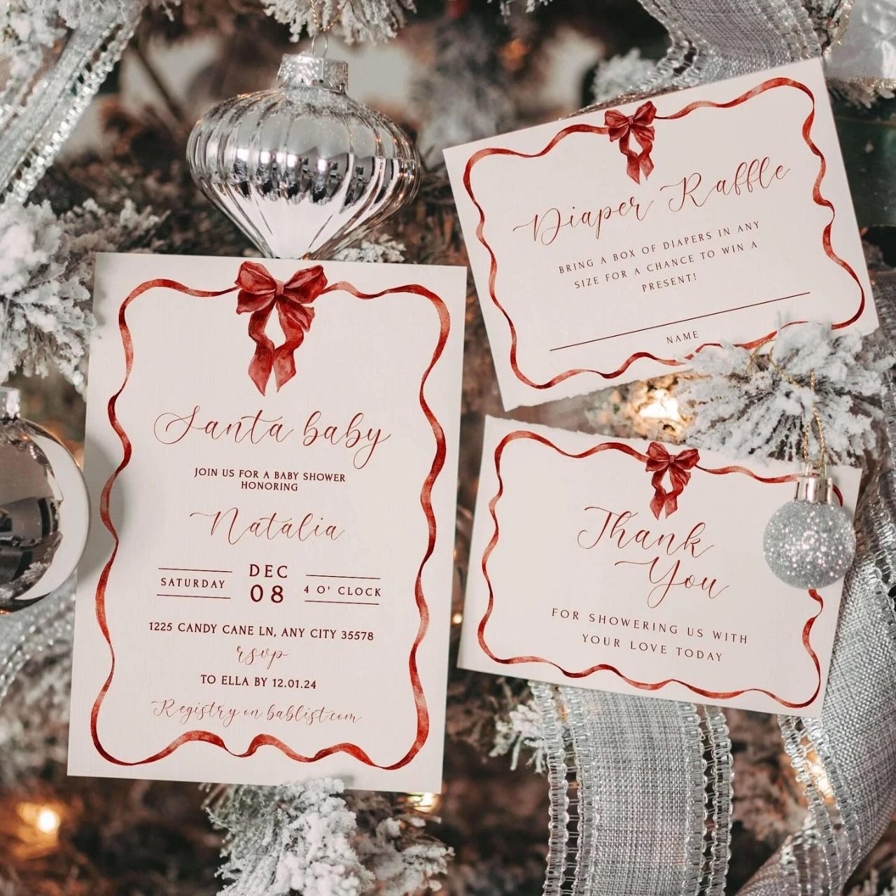 Santa Baby invitation suite with painted red ribbon borders, a silver ornament, and evergreen branches