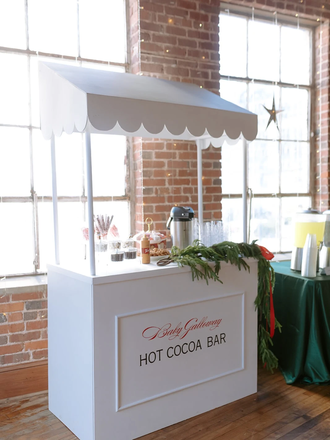 Cozy hot cocoa station with marshmallows, candy canes, syrups, and a hot water dispenser