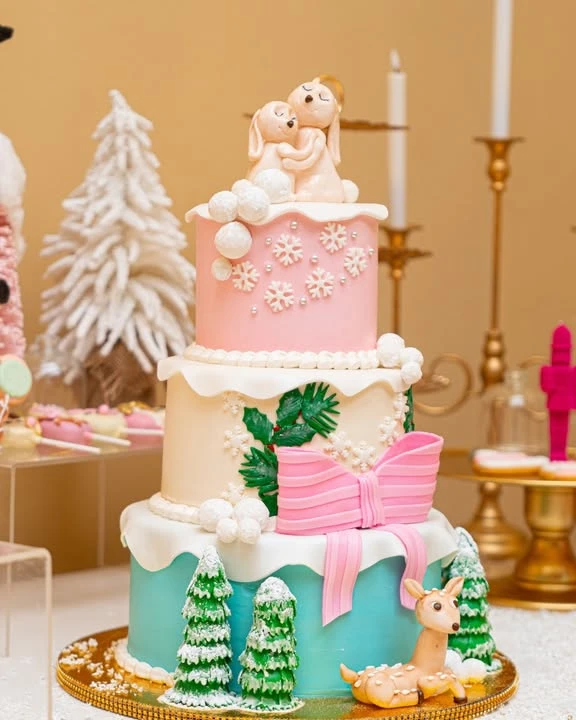 Winter woodland bunny cake decorated with fondant animals, pine trees, bows, and snowflakes