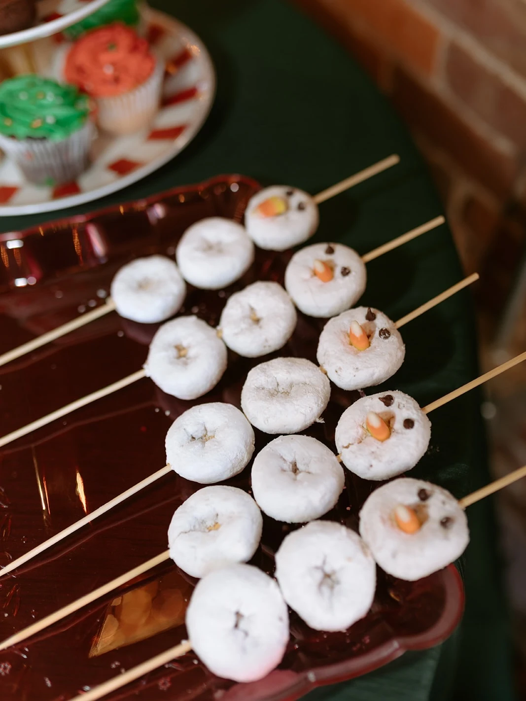 Baby shower hot cocoa bar displayed on a white wooden cart with pine garland